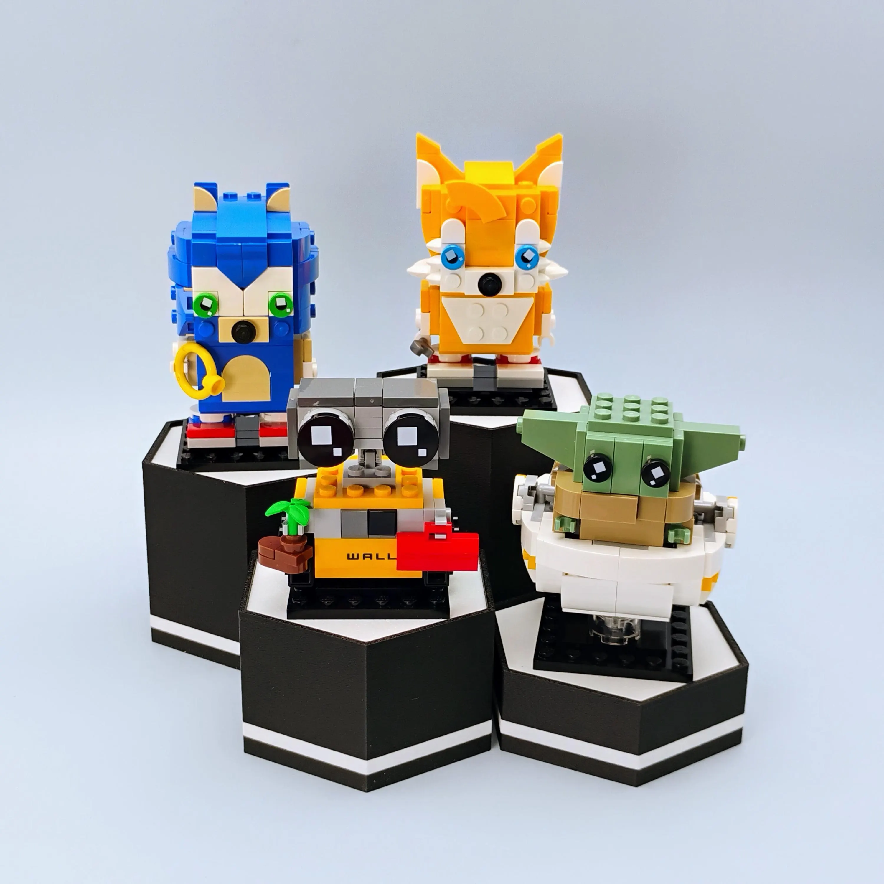 Matte black hexagonal BrickHeadz display stands arranged in a geometric pattern for modular setups.