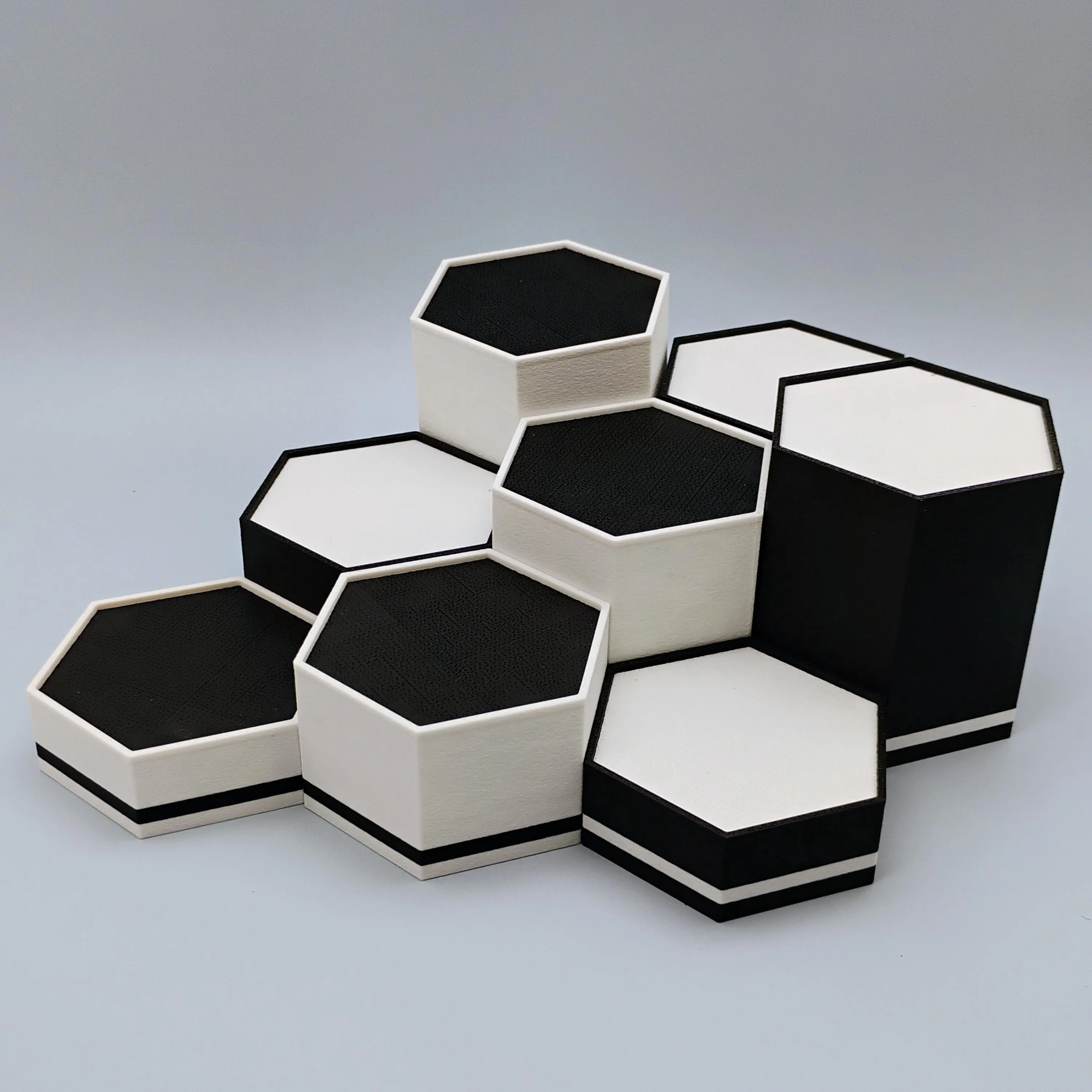 Combination of black and white hexagonal display stands aligned in a modular row showing geometric precision.