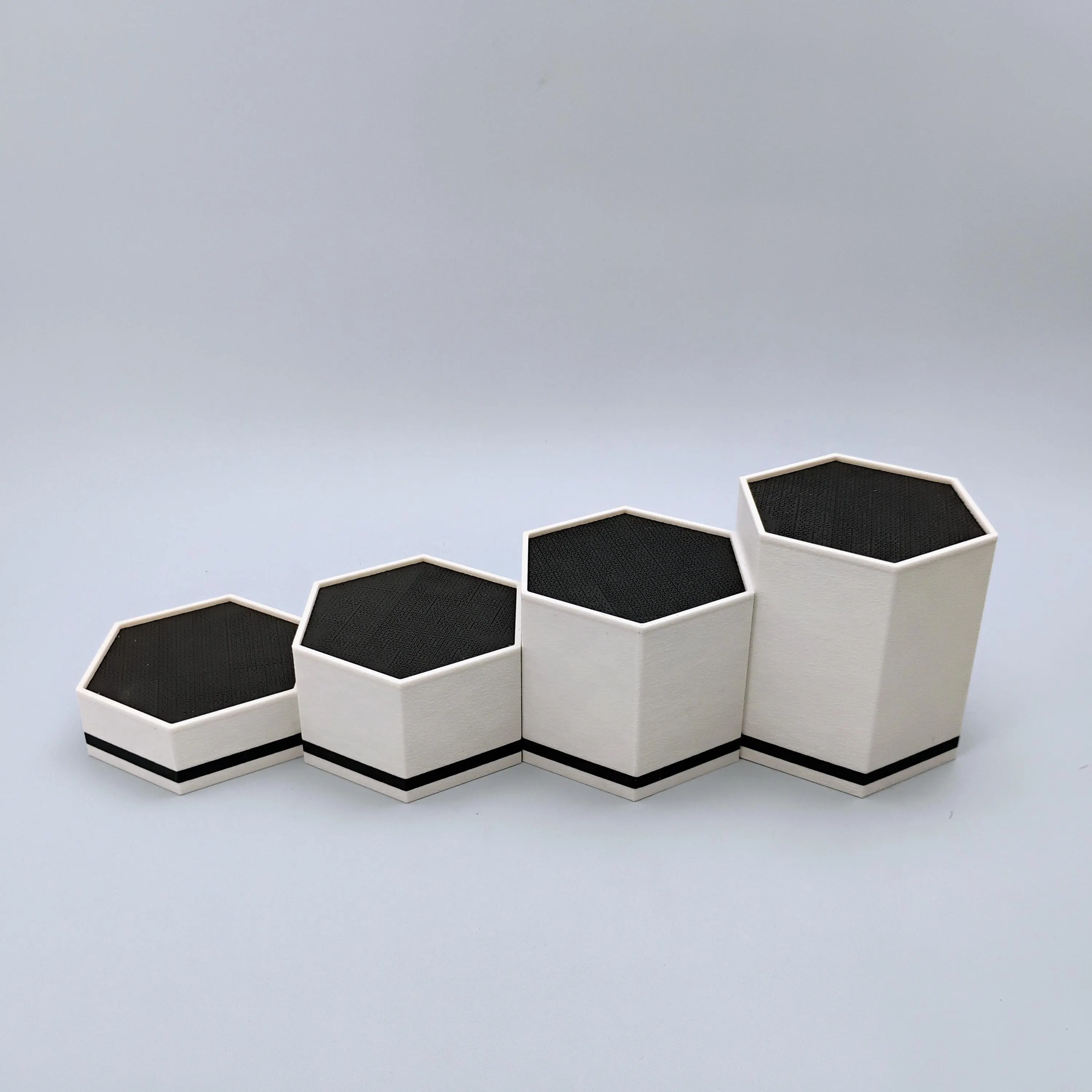 Empty matte white hexagonal display stands arranged in a clean minimalist layout.