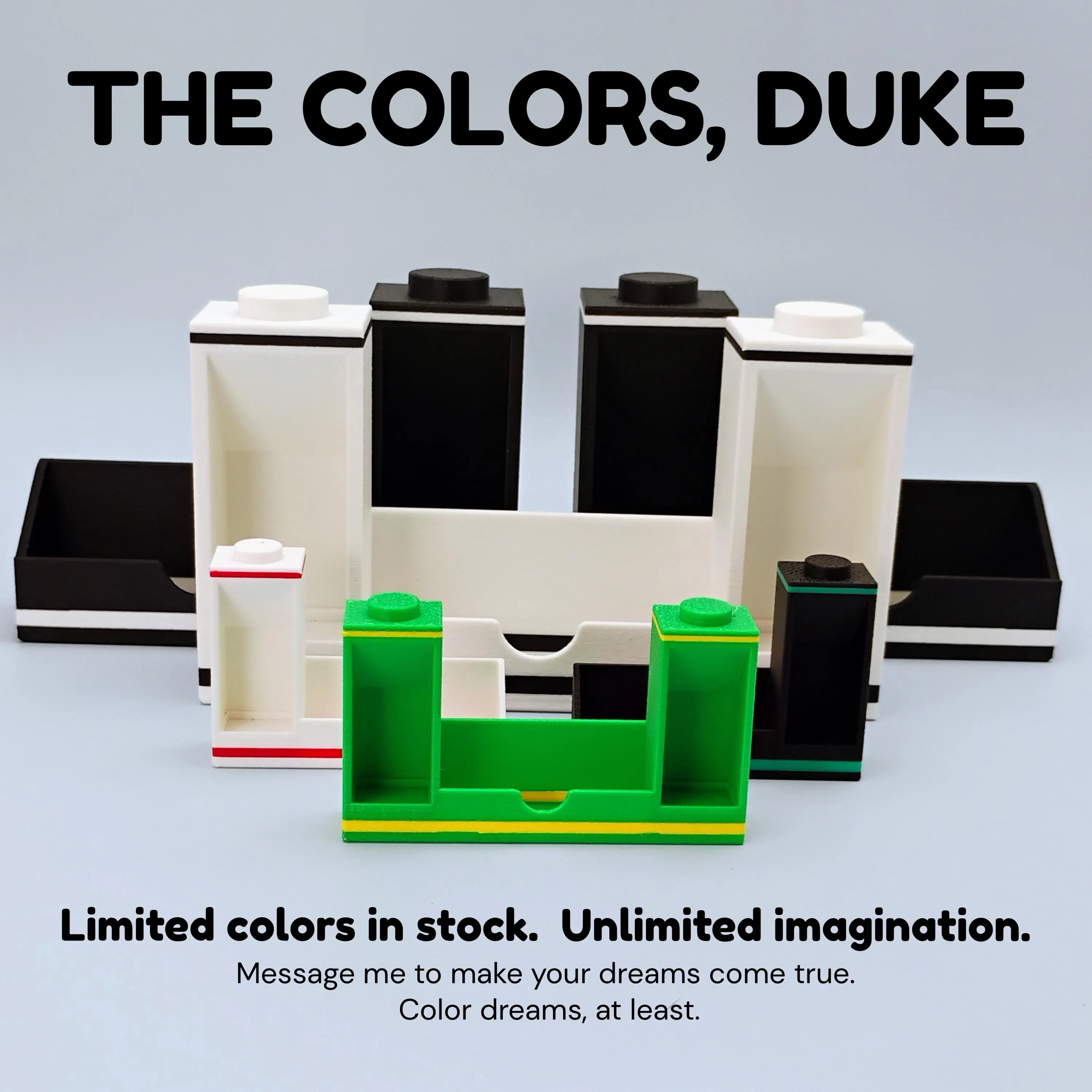 Color options for modular LEGO® minifigure bookend display stands in green, pink, red, and white, arranged beside business cards on a desk.