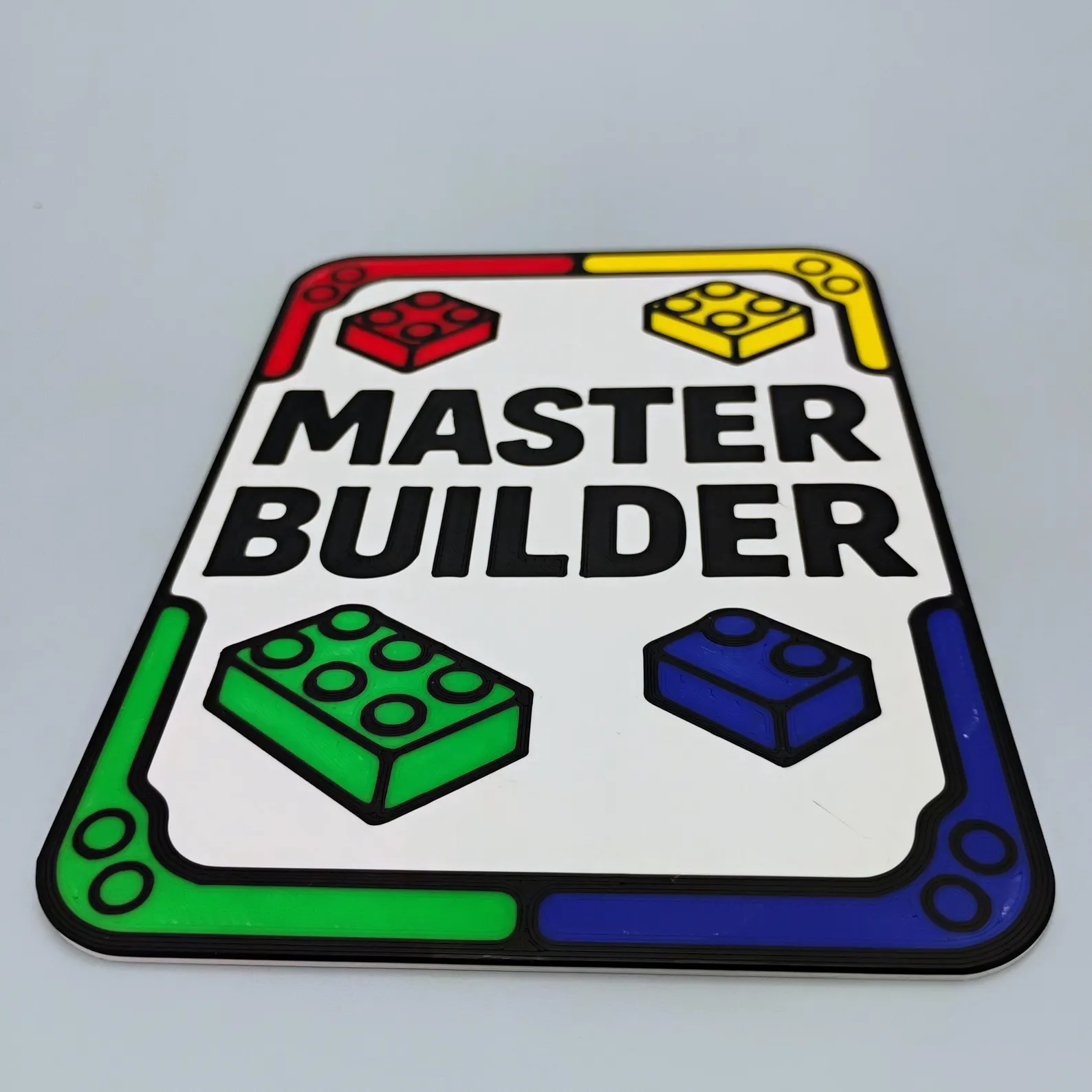 Master Builder sign close-up showing the bright brick color accents and clean, bold lettering.