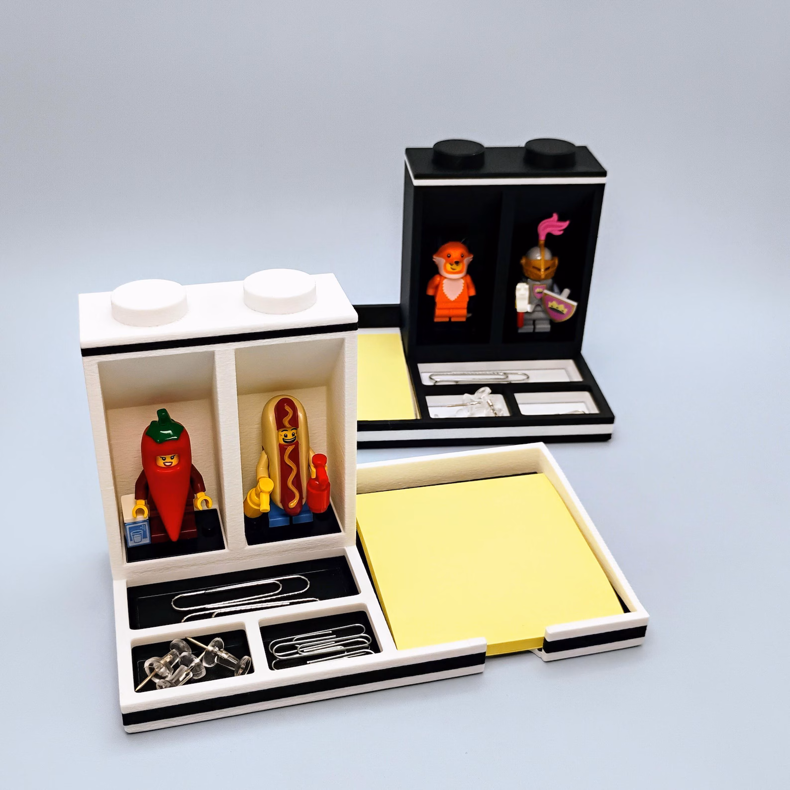 White LEGO minifigure desk organizer with Post-it note holder. Displays the lighter color option with space for two minifigures, upright pen storage, and a fitted area for standard sticky notes. Blends easily into bright desks, classrooms, or home offices.